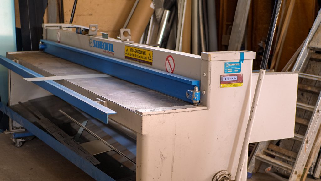 Machine de découpe d'aluminium pour la fabrication d'appuis de fenêtres, de descentes de gouttières et d'autres éléments de zinguerie.